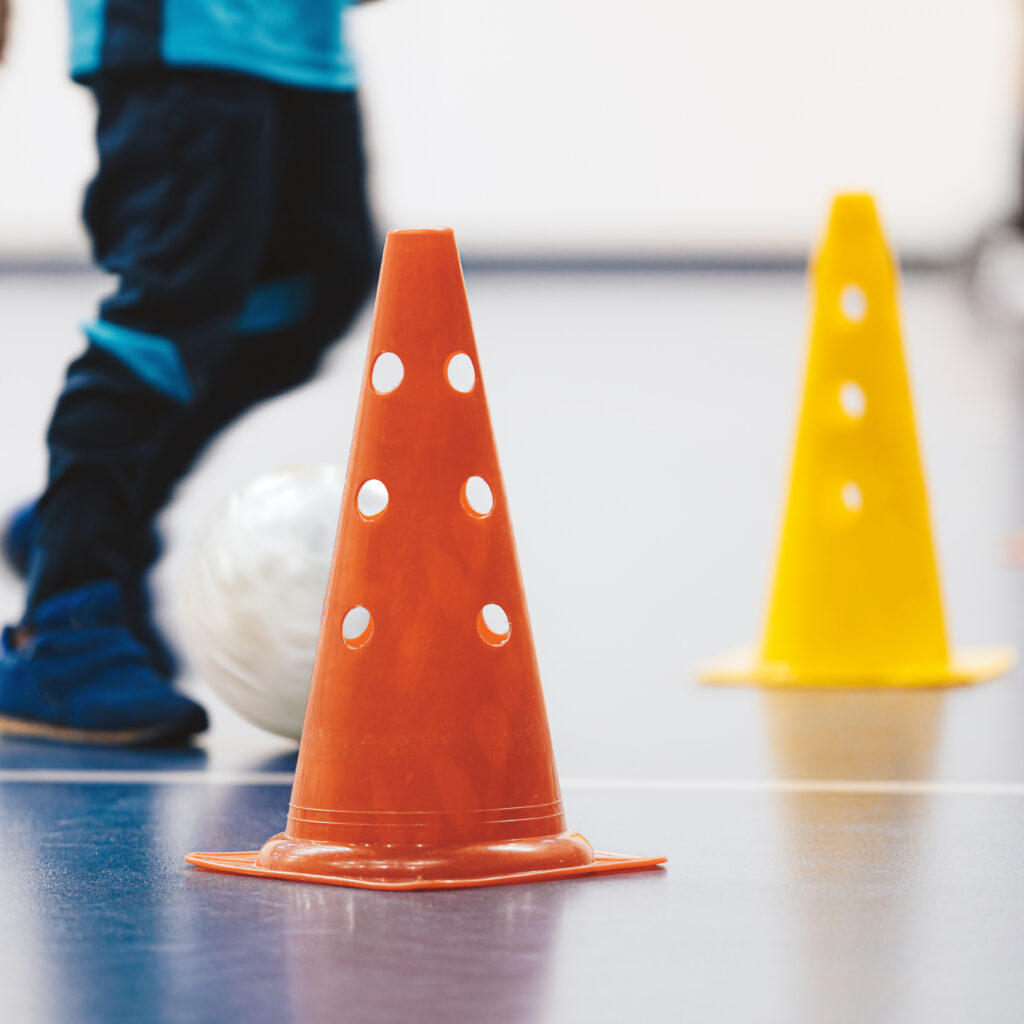 Futsal training drill for school children. Little boy kicking indoor soccer ball during practice training class